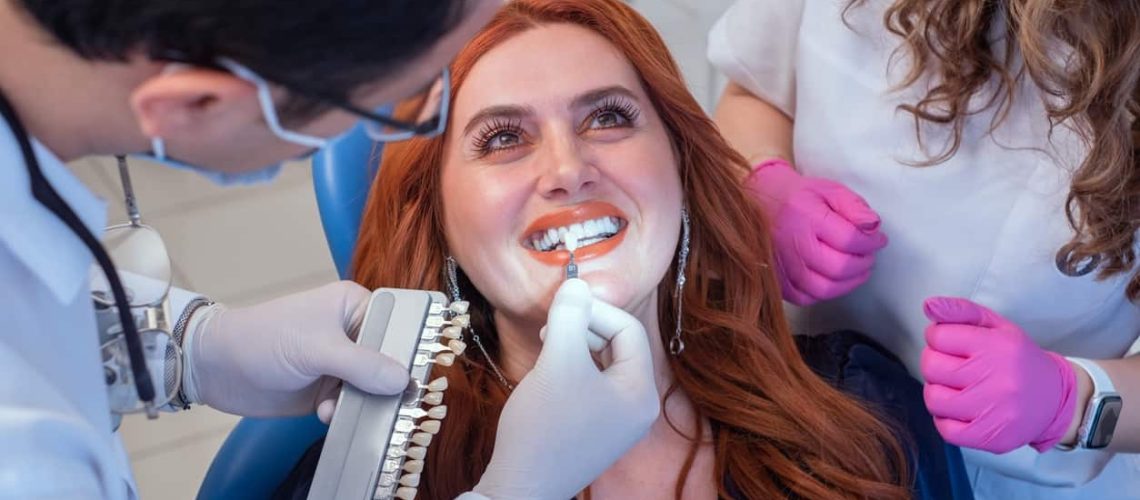 Dentist installing porcelain veneers on female client